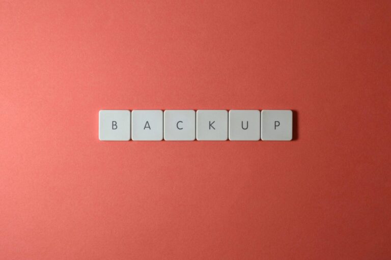 Free Close-up of keyboard keys spelling 'BACKUP' placed on a coral-colored surface. Stock Photo
